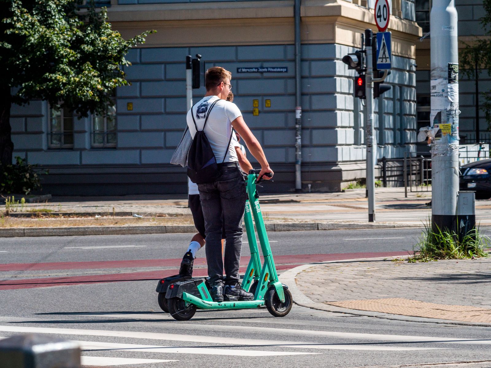 Voksen mann kjører elsparkesykkel på en bygate — ansvarsforsikring er påbudt for all kjøring i offentlig rom